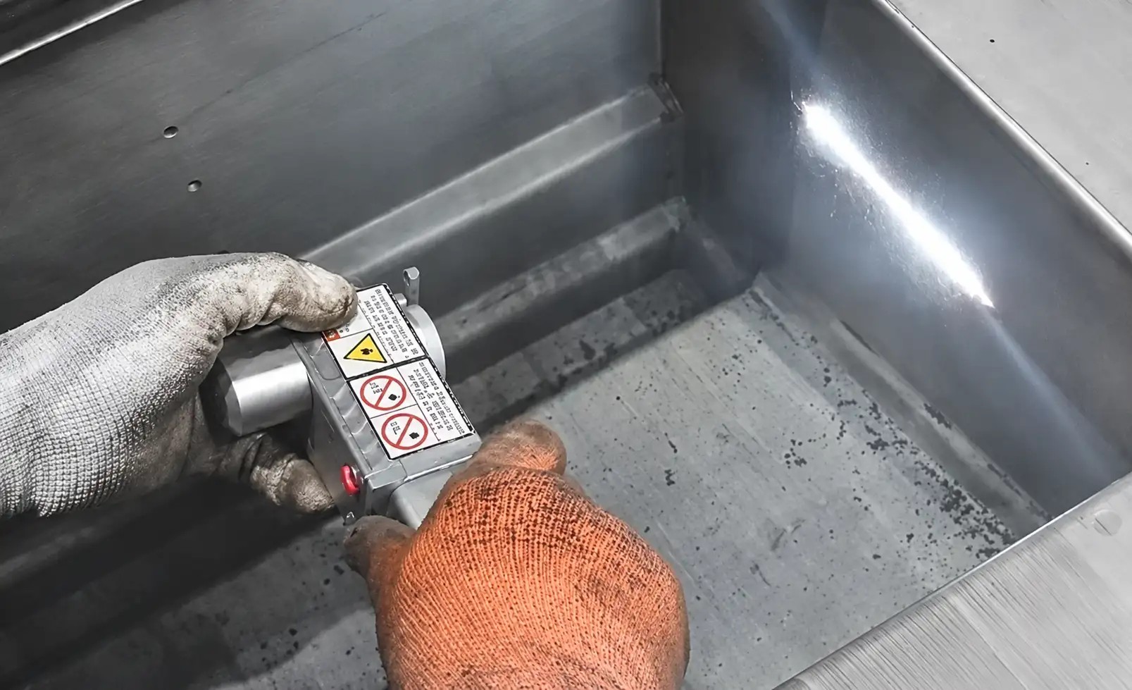 Laser cleaning carbon buildup from stainless steel kitchen equipment
